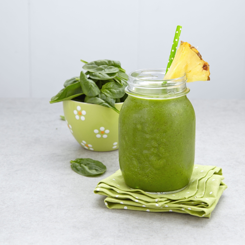 59150551 - spinach green smoothie topped with a pineapple slice