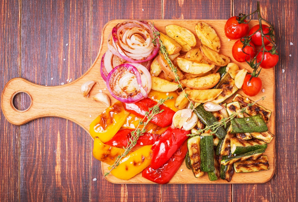 44246451 - grilled vegetables served on cutting board on dark wooden background