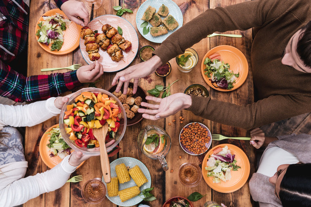 45974538 - friends having dinner. top view of four people having dinner together while sitting at the rustic wooden table